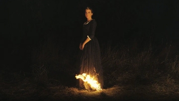 Adèle Haenel standing by a fire in Portrait of a Lady on Fire