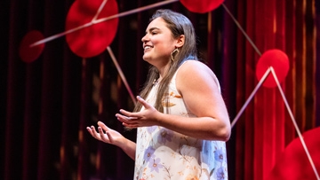 Person speaking on stage at TEDx event