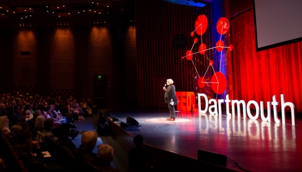 Person speaking on stage at TEDx event